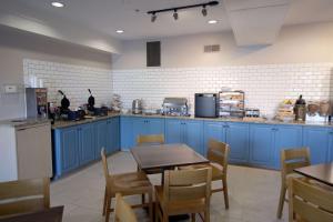 康瑟尔布拉夫斯卡尔森 - 康瑟尔布拉夫斯乡村套房酒店的厨房配有蓝色橱柜和桌椅
