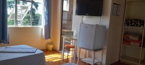 库里提巴HOTEL TROPICAL的厨房配有冰箱、桌子和窗户。