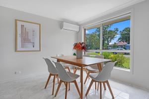 NarellanDiscover Mount Annan - Spacious 6-BR House的一间带桌椅和窗户的用餐室