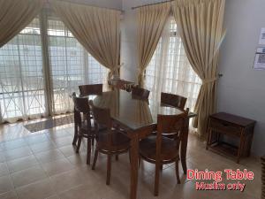 马六甲892 Villa Dfaro Afamosa Melaka的窗户间配有餐桌和椅子