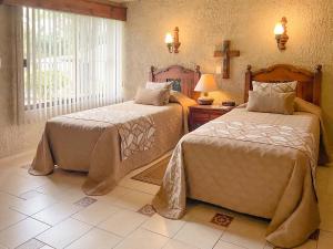 科尔多瓦Villas Layfer, Córdoba, Veracruz, Mexico的一间卧室设有两张床和窗户。