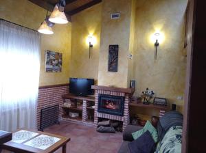 Navadijoscasa rural EL RICON的客厅设有壁炉和电视。