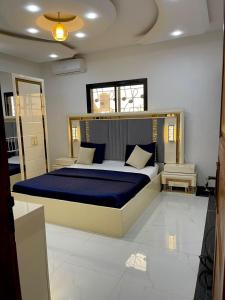 雅温得SkyLight Residence的一间卧室配有一张带蓝色毯子的大床
