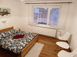 哈沃福卡Domcek na orave的一间卧室配有一张床、两把椅子和一个窗户
