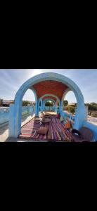 Najâ€˜ al MadÄbbNuba life Mostafa Guesthouse的享有带长椅和拱门的庭院的景色