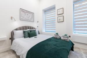 曼彻斯特Deansgate Luxury Apartments的一间卧室配有一张带绿毯的大床