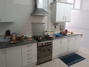 克洛伊奥斯Rooms in a Girl House near Corroios Train Station的厨房配有白色橱柜和炉灶烤箱。