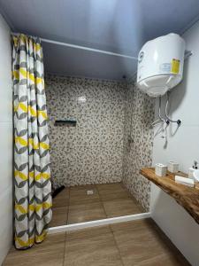 楚伊Monoambiente Freyja的浴室里设有黄色和白色窗帘的淋浴