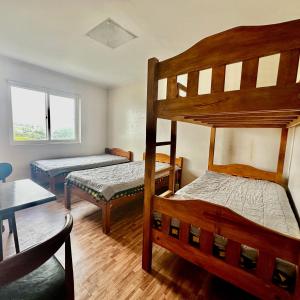 碧瑶Baguio BELL Staycation的一间卧室设有两张双层床和一张桌子