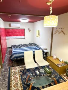 京都Hotel Rakusai的一间卧室配有一张床和两把白色椅子