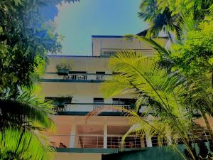 代尼耶耶Rainforest Lodge, Deniyaya的一座高大的建筑,前面有棕榈树