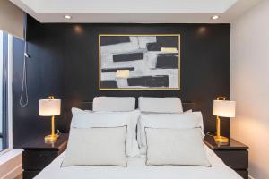 渥太华Westview Luxury Suites的一间卧室设有黑色墙壁和一张带白色枕头的床。