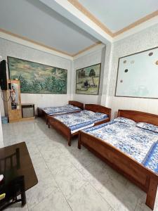 Ấp Bình HưngNhà Nghỉ Phố Biển Phan Thiết的一间卧室配有两张床、一张桌子和一台电视。