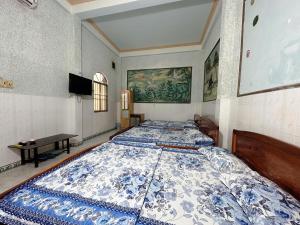 Ấp Bình HưngNhà Nghỉ Phố Biển Phan Thiết的一间卧室配有两张带蓝白色床罩的床