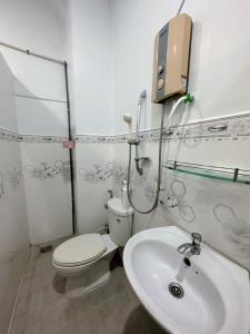 Ấp Bình HưngNhà Nghỉ Phố Biển Phan Thiết的白色的浴室设有卫生间和水槽。