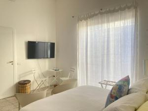 莱乌卡fuoridalgusciohome的一间卧室设有一张床和一个带电视的窗户。