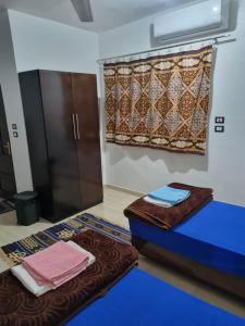 阿斯旺ABAZIDO Nubian Guest House的配有床、窗帘和毛巾的客房