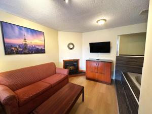 加纳诺克Riviera Inn And Suites 1000 Islands的带沙发和平面电视的客厅