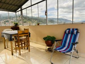 瓦拉斯Yerupaja Mountain Hostel的阳台配有桌椅和窗户。