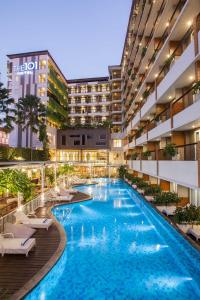 日惹日惹图古1O1酒店的一张酒店游泳池的图片,里面设有躺椅