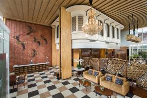 日惹日惹图古1O1酒店的大堂配有沙发、桌子和吊灯
