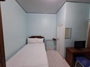 班达楠榜OYO 93695 Guest House Riharti Syariah的一间小卧室,配有一张床和电视