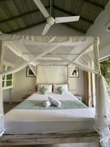 乌纳瓦图纳奥洛拉住宿加早餐旅馆的一间卧室配有一张天蓬床和两张毛巾