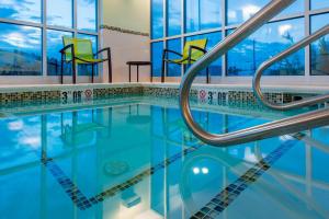 盖洛普盖洛普万豪春季山丘套房酒店的游泳池设有蓝色的海水和黄色的椅子