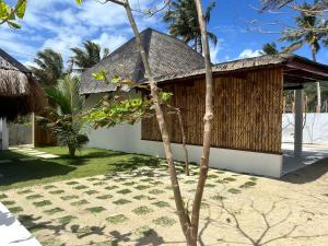 San IsidroYapak Beach Villas的一座带草屋顶的小建筑