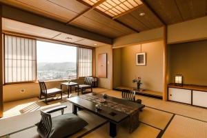 藏王かっぱの宿旅館三治郎的客厅配有桌椅和大窗户