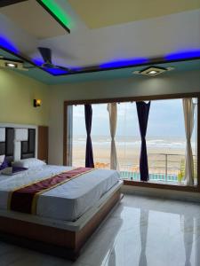 曼达莫尼ST Apple Beach Resort Mandarmani的一间卧室配有一张床,享有海滩美景