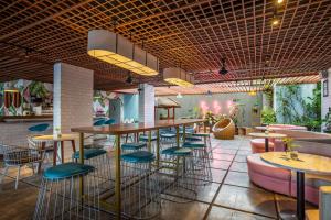 塞米亚克利伯塔水明漾酒店的餐厅设有酒吧,配有凳子和桌子