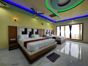 曼达莫尼ST Apple Beach Resort Mandarmani的大型客房的两张床,配有紫色灯