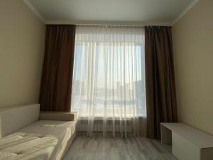 PrigorodnyyЖК Sati Club House的一间卧室设有一张床和一个大窗户