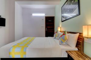 班加罗尔OYO Home Exotic Stay Bsk 3rd Stage的卧室配有一张带彩色枕头的大型白色床。
