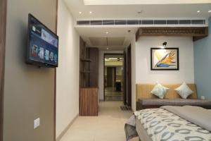 MohaliHOTEL CENTRA的一间卧室配有一张床和一台平面电视