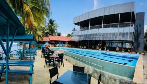 卡图纳耶克New Saniro Lagoon Deck的一座带桌椅的游泳池位于酒店大楼旁