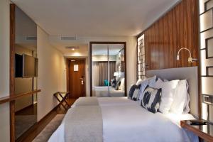 里斯本特里姆阿拉萨尔达尼亚酒店 的卧室配有一张白色大床和电视。