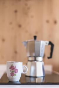 IvanjkovciGlamping house Julija - Wellness & View的咖啡壶和柜台上的咖啡杯