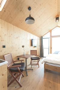 IvanjkovciGlamping house Julija - Wellness & View的卧室配有一张床和一张桌子及椅子