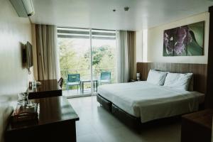 塔比拉兰保和海景套房精品酒店的配有一张床、一张书桌和一扇窗户的酒店客房