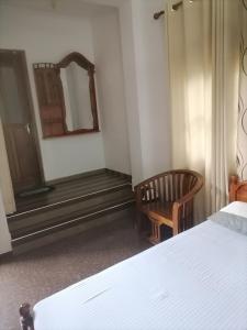 韦勒沃耶Lavista Holiday Bungalow的一间卧室配有一张床、镜子和椅子