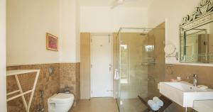 古尔冈Karma Chalets的浴室配有卫生间、盥洗盆和淋浴。