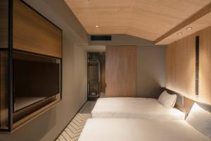 大阪Hotel Keihan Tenmabashi Ekimae的一间卧室配有两张床和一台平面电视