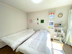东京Gest Residence EDORIVER Airport Line Self check in的卧室配有白色的床和窗户。