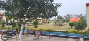 AyodhyaUtsav Vatika的停在树边的摩托车和游乐场