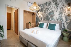 埃拉特Almogim Suites Eilat的卧室配有带蓝色枕头的大型白色床