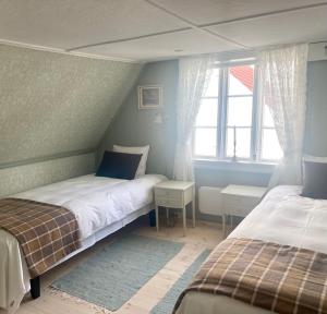 SkudeneshavnReinertsenhuset的一间卧室设有两张床和窗户。