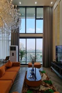 河内Penthouse Cao Cấp Tại Hà Nội的带沙发和大窗户的客厅