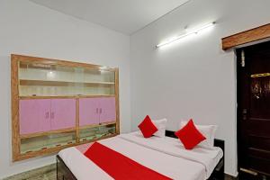 瓦拉纳西Super OYO Flagship Shivansh Paying Guest House的一间卧室配有两张带红色枕头的床和窗户。